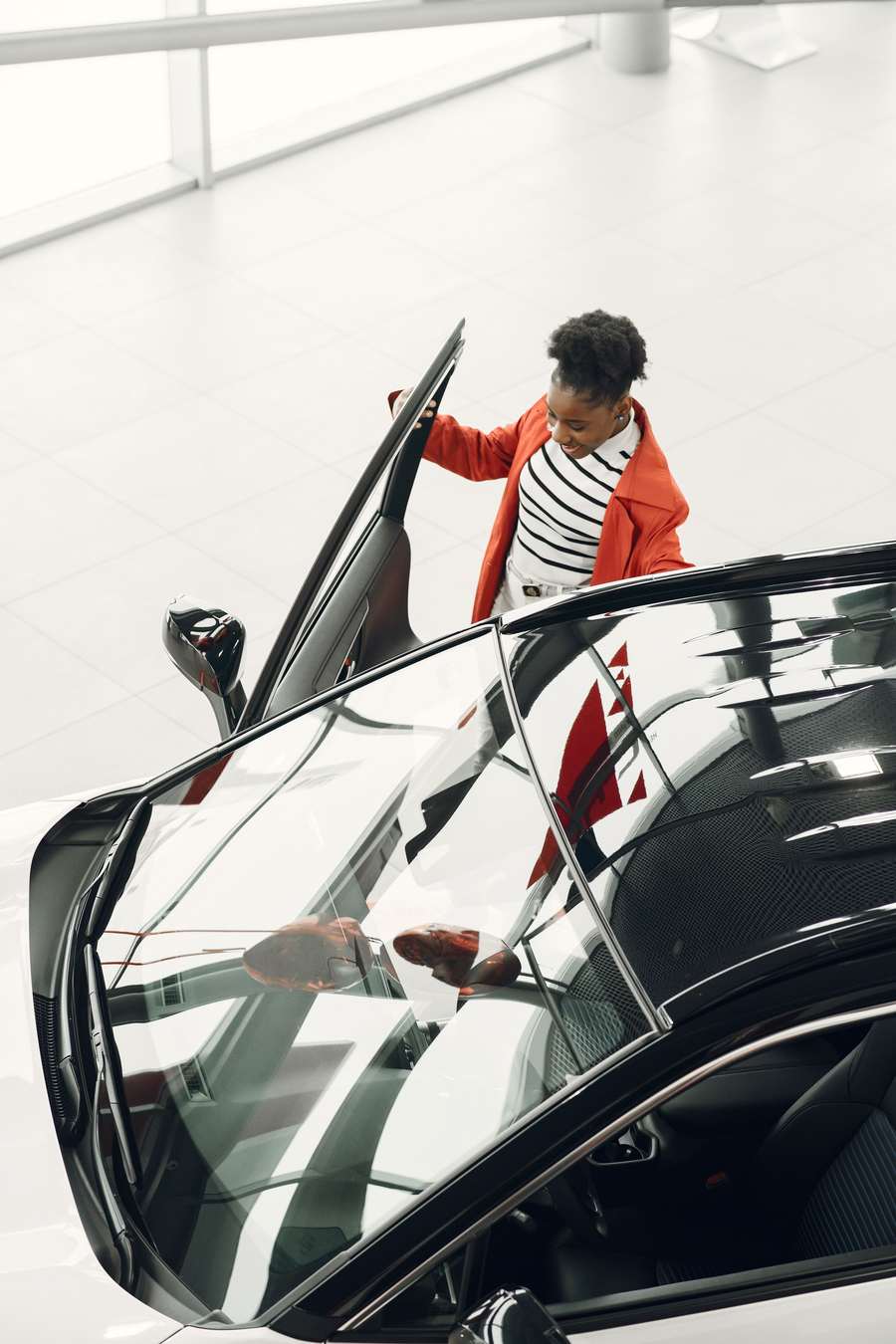 woman opening car door in a car showroom